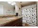 Bathroom showcasing a dark vanity with a granite countertop and a shower with a decorative curtain at 5044 W Electra Ln, Glendale, AZ 85310