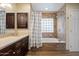Well-lit bathroom showcasing a vanity with dark cabinets and a bathtub with tiled walls at 5044 W Electra Ln, Glendale, AZ 85310