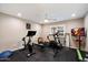 Modern exercise room with ceiling fan and fitness equipment including a stationary bike, rowing machine, and treadmill at 5044 W Electra Ln, Glendale, AZ 85310