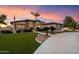Stunning home with lush lawn, mature trees, and charming curb appeal at sunset at 5044 W Electra Ln, Glendale, AZ 85310