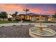Elegant home featuring beautiful landscaping and fountain against a vibrant sunset backdrop at 5044 W Electra Ln, Glendale, AZ 85310