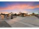 Home featuring a long driveway leading to garages, a well-manicured lawn, and a gated entrance at 5044 W Electra Ln, Glendale, AZ 85310