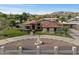 Inviting front of home with manicured lawn, circular driveway, charming fountain, and privacy gate at 5044 W Electra Ln, Glendale, AZ 85310