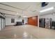 Spacious garage with epoxy floors, built-in storage cabinets, refrigerator, mini split air conditioner, and a hot tub at 5044 W Electra Ln, Glendale, AZ 85310