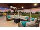 Comfortable outdoor living area with a large sectional sofa, fire pit, string lights, and a view of the backyard at 5044 W Electra Ln, Glendale, AZ 85310