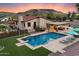 Inviting backyard with a sparkling pool, covered patio, and well-maintained landscaping at 5044 W Electra Ln, Glendale, AZ 85310