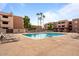 Sparkling community pool area surrounded by lounge chairs, palm trees and condominium buildings at 540 N May -- # 2110, Mesa, AZ 85201