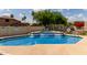 Community pool with a jacuzzi, lush greenery, and seating at 5445 E Mckellips Rd # 48, Mesa, AZ 85215