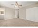 Spacious bedroom with neutral walls, plush carpet, ceiling fan, and an ensuite bathroom at 5818 E Colby St, Mesa, AZ 85205