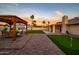 Entertain in the expansive backyard featuring a putting green, covered patio, and desert landscaping at 5922 W Michelle Dr, Glendale, AZ 85308