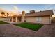 Relax in this backyard featuring a synthetic putting green, covered patio, and desert landscaping at 5922 W Michelle Dr, Glendale, AZ 85308
