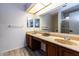 Bathroom with double sinks, wood cabinets, and laminate floors at 5922 W Michelle Dr, Glendale, AZ 85308