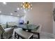 Spacious dining area featuring modern chandelier, glass table and ceramic tile flooring at 5922 W Michelle Dr, Glendale, AZ 85308
