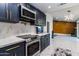 Modern kitchen featuring stainless steel appliances, navy cabinets, and white countertops at 5922 W Michelle Dr, Glendale, AZ 85308
