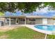 Lush backyard featuring a sparkling pool, covered patio, and well-maintained lawn, perfect for relaxing at 5926 S Newberry Rd, Tempe, AZ 85283