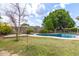 Spacious backyard featuring a pool and deck, surrounded by trees and lush greenery at 5926 S Newberry Rd, Tempe, AZ 85283