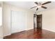 Bedroom with hardwood floors, ceiling fan, and a closet with sliding doors at 5926 S Newberry Rd, Tempe, AZ 85283
