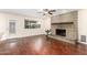 Spacious living room with hardwood floors, brick fireplace, and a large window at 5926 S Newberry Rd, Tempe, AZ 85283