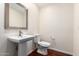 Simple powder room with pedestal sink, toilet, and large mirror at 5926 S Newberry Rd, Tempe, AZ 85283
