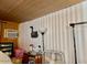 Cozy room featuring wood-paneled walls, built-in AC, and an eclectic mix of furnishings at 5933 E Main St # 114, Mesa, AZ 85206
