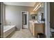 Bright bathroom with double vanity, soaking tub, and tiled floor at 6811 W Darrel Rd, Laveen, AZ 85339