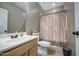 Traditional bathroom features a single sink vanity, toilet, and shower with patterned curtain at 6811 W Darrel Rd, Laveen, AZ 85339