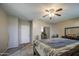 Well-lit bedroom with ceiling fan, neutral walls, carpet and views into the adjacent room at 6811 W Darrel Rd, Laveen, AZ 85339