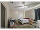 This bedroom features a ceiling fan, window with curtains, and carpeted floor at 6811 W Darrel Rd, Laveen, AZ 85339