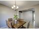 Well-lit dining area featuring a rustic wooden table, chandelier, creating a perfect setting for gatherings at 6811 W Darrel Rd, Laveen, AZ 85339