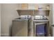 Laundry room featuring modern washer and dryer units with shelving above at 6811 W Darrel Rd, Laveen, AZ 85339