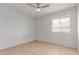 A clean bedroom featuring neutral walls, ceiling fan, tiled floor, and natural light from a window at 6901 W Mackenzie Dr # 1287, Phoenix, AZ 85033