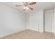 A bright bedroom with neutral walls, a ceiling fan, a tiled floor, and a closet at 6901 W Mackenzie Dr # 1287, Phoenix, AZ 85033