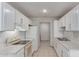 Kitchen with white cabinets, tile floors, and white appliances at 6901 W Mackenzie Dr # 1287, Phoenix, AZ 85033