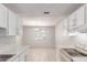 Kitchen with white cabinets, tile floors, and an adjacent dining area at 6901 W Mackenzie Dr # 1287, Phoenix, AZ 85033