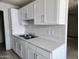Bright kitchen with white cabinets, tile floors and stainless steel sink at 6901 W Mackenzie Dr # 1287, Phoenix, AZ 85033