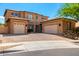 Attractive exterior of a tan two-story house with a three-car garage and large paver driveway at 8830 S 20Th S Pl, Phoenix, AZ 85042