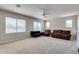 Expansive living room with multiple windows, ceiling fan, neutral walls and carpet, offering versatile layout options at 8830 S 20Th S Pl, Phoenix, AZ 85042
