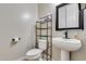 Compact half bathroom with a pedestal sink, framed mirror, and a toilet with a storage unit at 8830 S 20Th S Pl, Phoenix, AZ 85042
