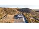 Elevated view of a contemporary home with clean lines, perfectly integrated into the rugged beauty of the desert hillside at 9357 W Canyon Verde Dr, Casa Grande, AZ 85194