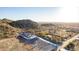 Expansive aerial view of a desert property featuring a modern home with stunning mountain views at 9357 W Canyon Verde Dr, Casa Grande, AZ 85194