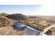 Scenic aerial shot of a desert home, blending seamlessly into its mountainous surroundings with cacti and native vegetation at 9357 W Canyon Verde Dr, Casa Grande, AZ 85194