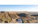 Remote aerial view of a desert home nestled in the mountains with vast landscapes at 9357 W Canyon Verde Dr, Casa Grande, AZ 85194