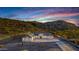 Aerial view of a desert home, highlighting the desert landscaping and mountain backdrop at dusk at 9357 W Canyon Verde Dr, Casa Grande, AZ 85194