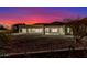 The backyard features desert landscaping and a twilight view of the home's back exterior at 9357 W Canyon Verde Dr, Casa Grande, AZ 85194