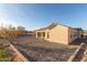 Desert landscaped backyard featuring a modern home with clean lines and a covered patio at 9357 W Canyon Verde Dr, Casa Grande, AZ 85194