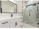 Bathroom featuring a white vanity, black hardware, a large mirror, and glass shower at 9357 W Canyon Verde Dr, Casa Grande, AZ 85194