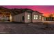 Side view of a desert home with mountain backdrop and desert landscaping at sunset at 9357 W Canyon Verde Dr, Casa Grande, AZ 85194