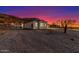Night shot of a desert home with soft exterior lighting, creating a warm and inviting atmosphere against the dramatic sky at 9357 W Canyon Verde Dr, Casa Grande, AZ 85194