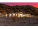 View of desert home with desert landscaping and mountain backdrop during a colorful sunset at 9357 W Canyon Verde Dr, Casa Grande, AZ 85194