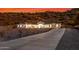 Desert home exterior featuring desert landscaping and a long driveway at dusk at 9357 W Canyon Verde Dr, Casa Grande, AZ 85194